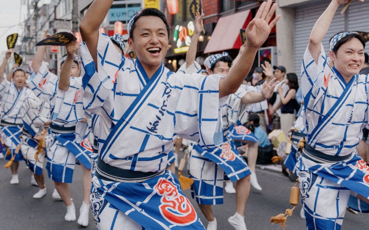 揃いの法被で通りを列になって進む踊り手たち