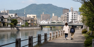 広島市の川沿いの住宅地を親子で歩く様子