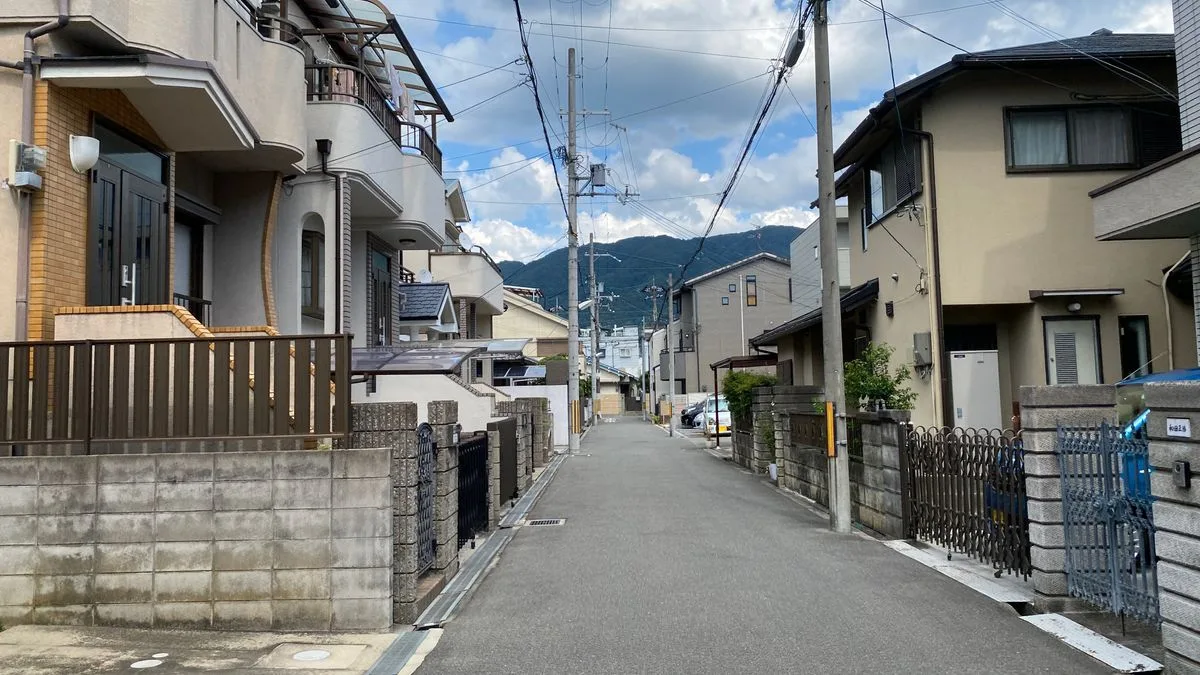 日差しと影が出ている日本の住宅街。奥に山が見える