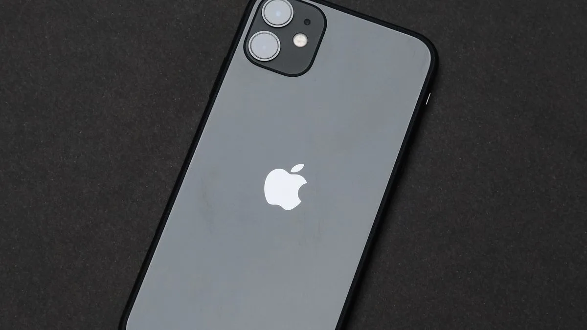 暗い背景に置かれたスマートフォンの背面。Appleのロゴが見えている