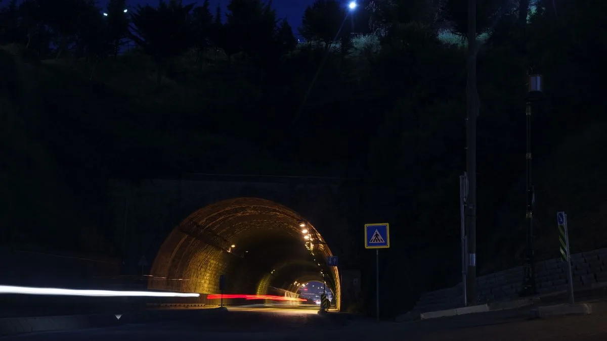 夜のトンネルを長時間露光で撮った写真。車のライトが光の線になって伸びている