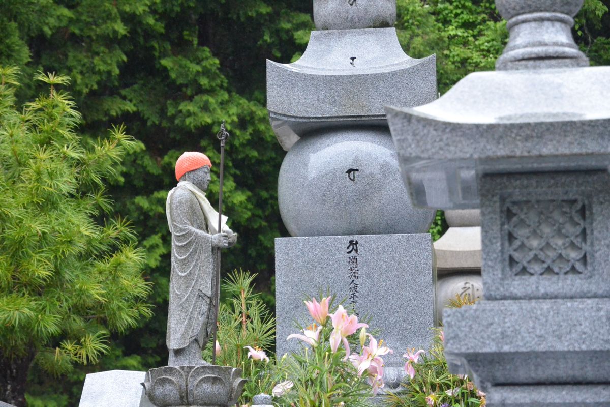 緑に囲まれた日本の墓地。石塔と灯籠が並ぶ静かな風景