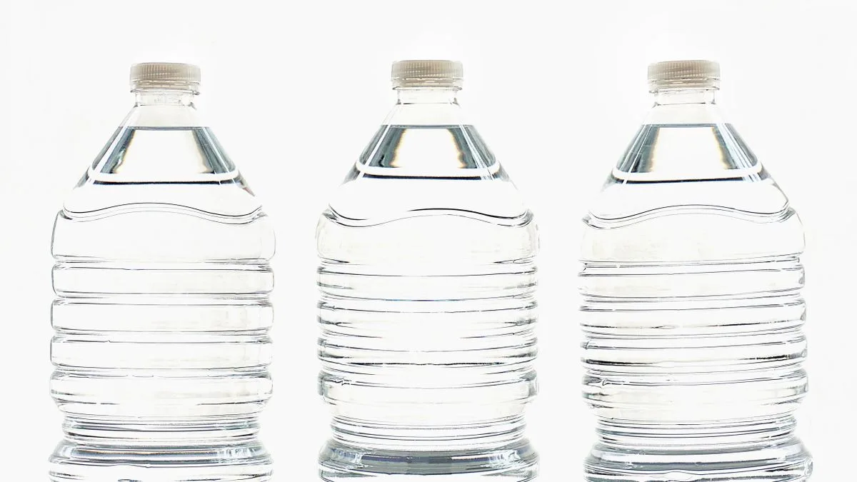 水を入れた透明なペットボトルが3本、白い背景の前に並んでいる
