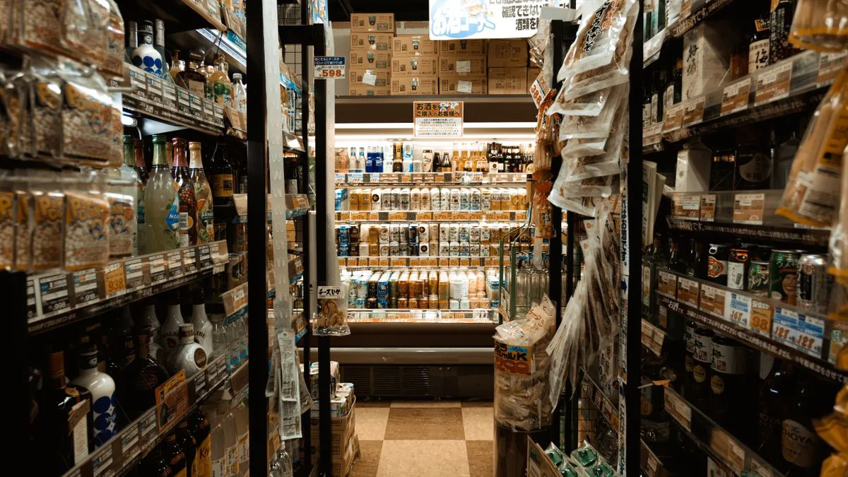コンビニの通路。両側の棚に商品がぎっしり並んでいる
