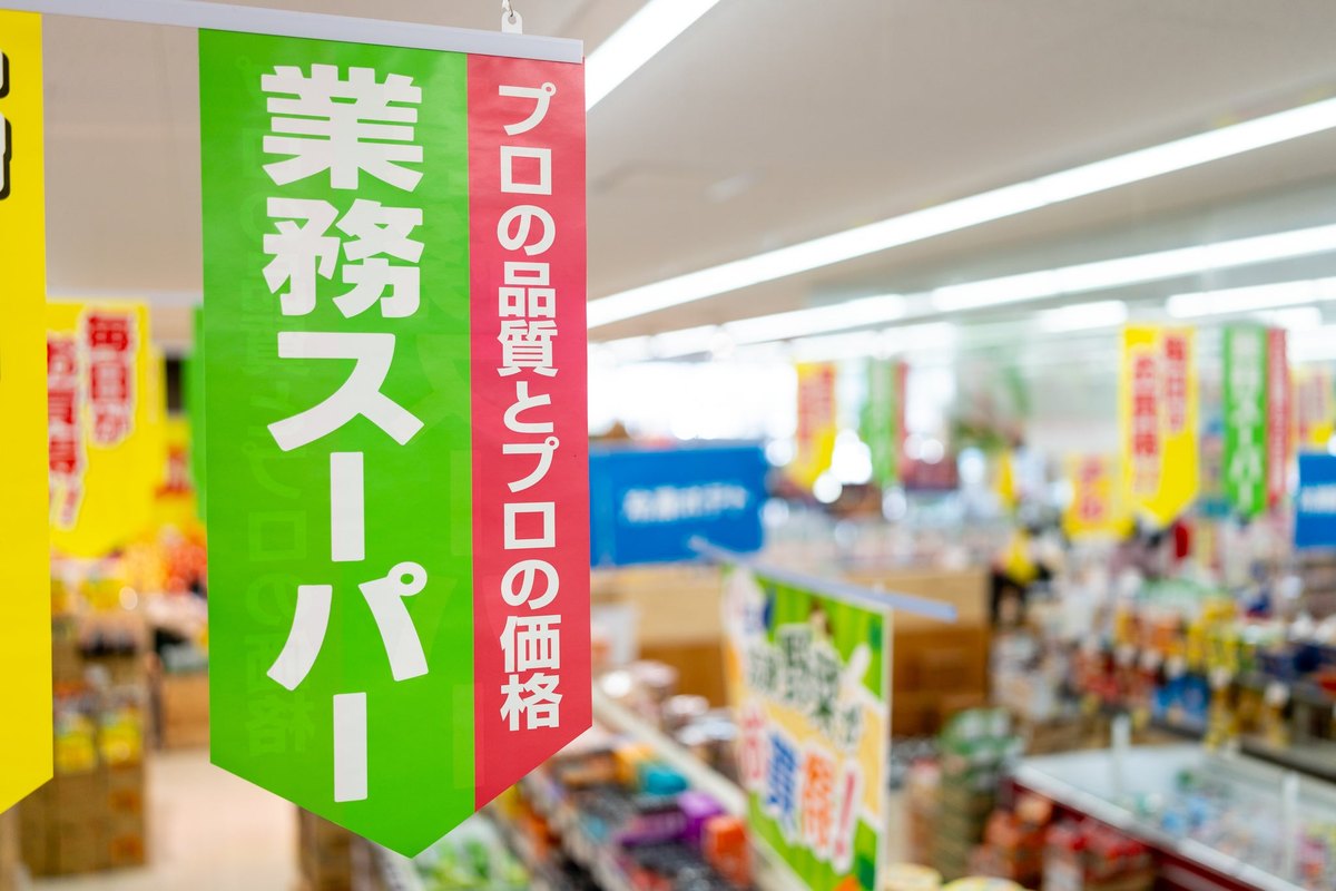 業務スーパーの店内。緑ののぼりと商品棚が並ぶ