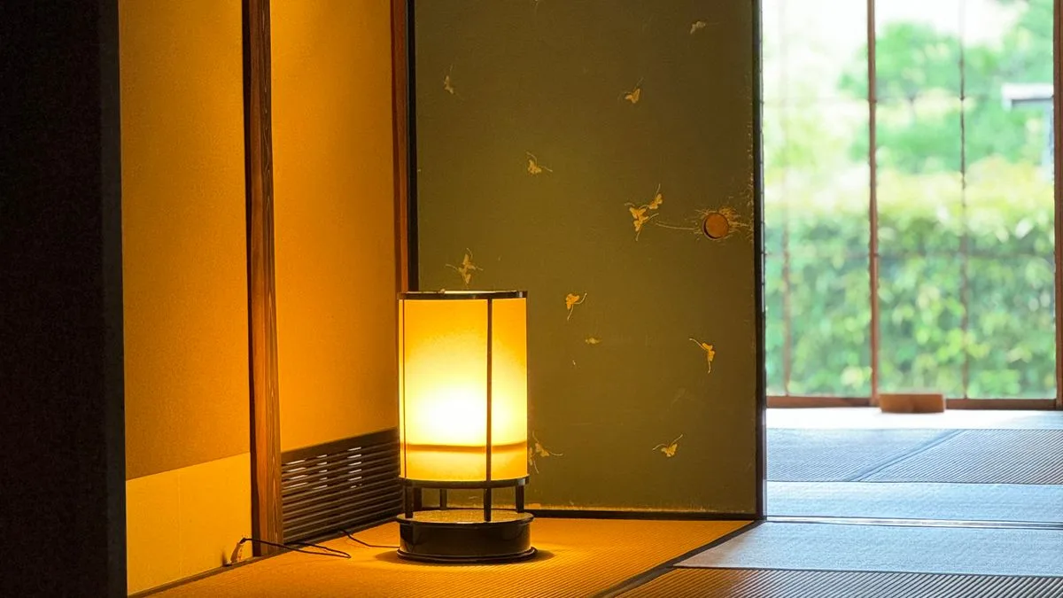 夜、部屋の中の行灯の明かりのまわりに小さな虫が集まっている