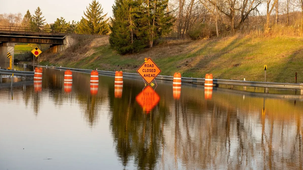 冠水した道路の水面から、オレンジ色の道路標識だけが突き出している