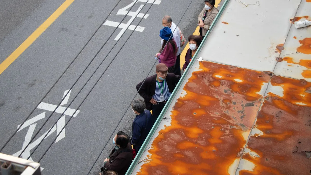 道路のわきに一列に並んで待つ人たちを上から見たところ