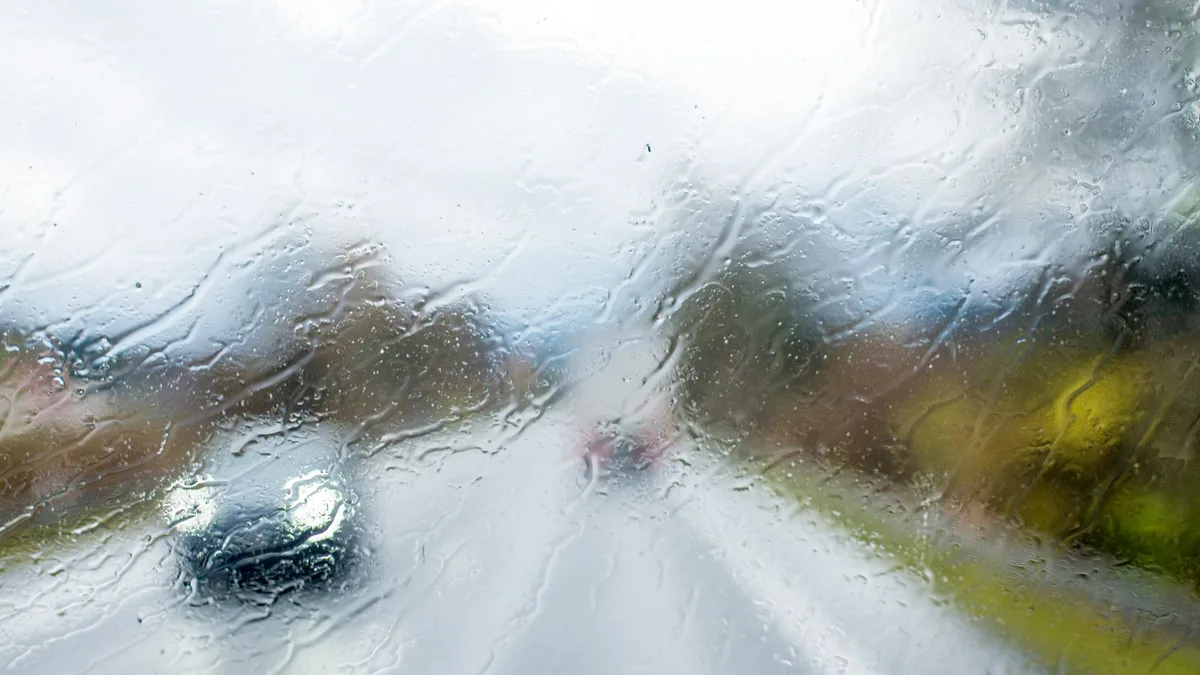 大雨の中を走る車のフロントガラス越しの視界
