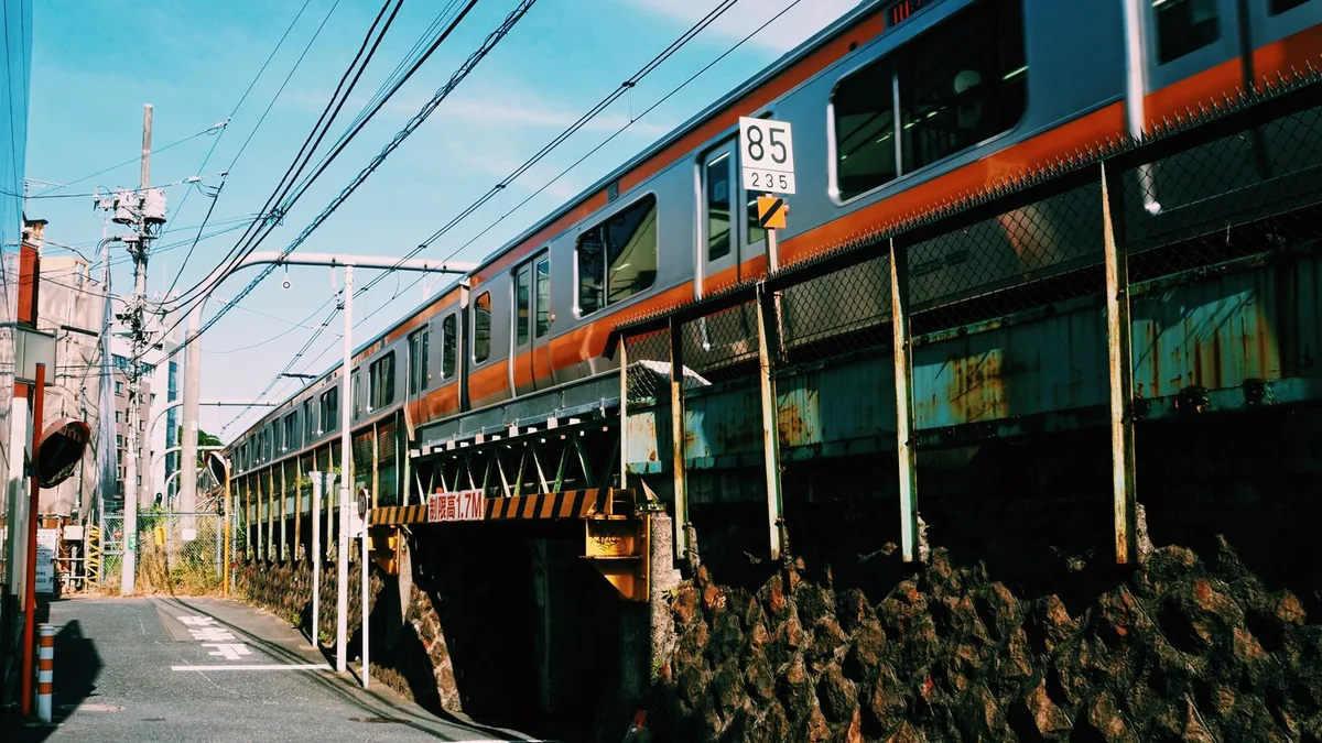 高架を電車が通り、その下を細い道が抜けている