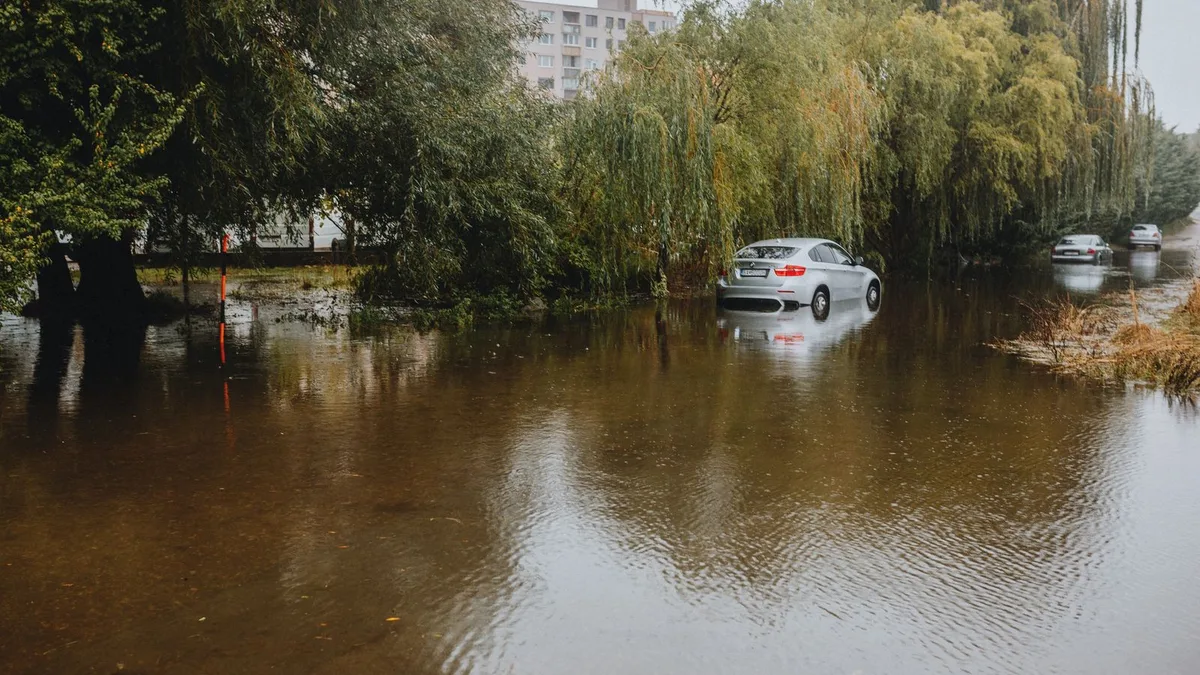 冠水した道路に取り残され、ドアの高さまで水に浸かった乗用車