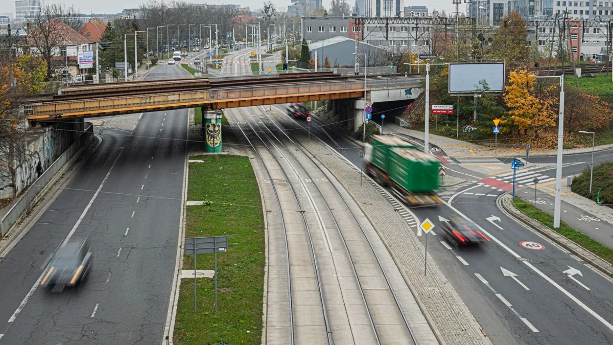 幅の広い道路をまたぐ鉄道の橋と、その下をくぐる車線