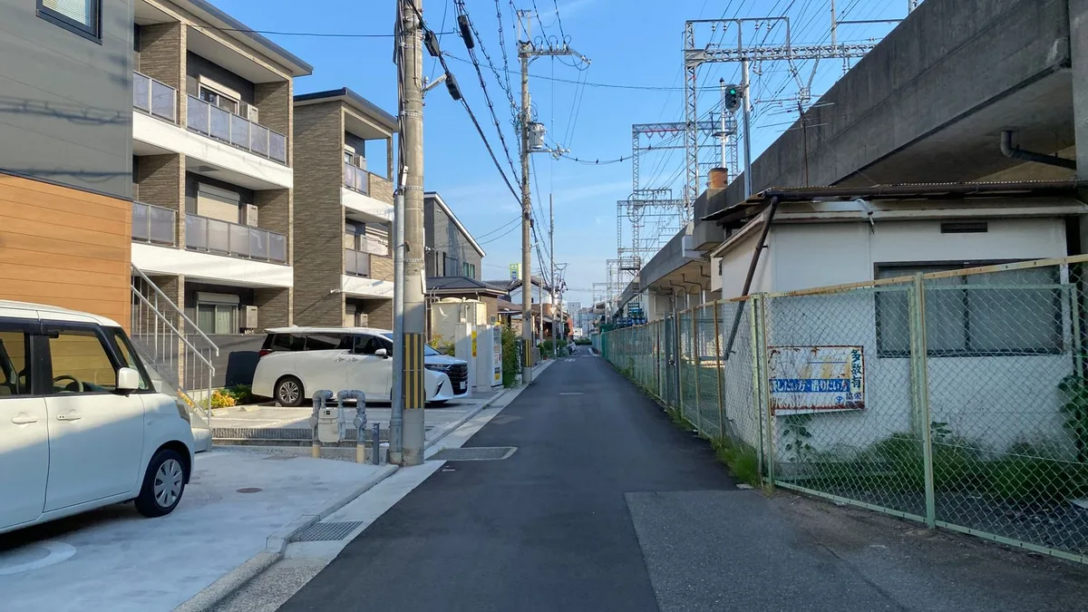 住宅街の細い道が、鉄道の高架に向かってまっすぐ伸びている
