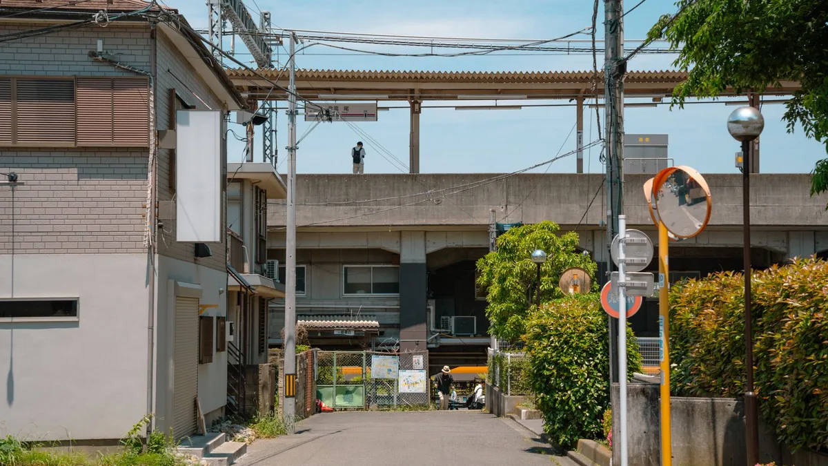 高いところを通る線路の下をくぐっていく細い道