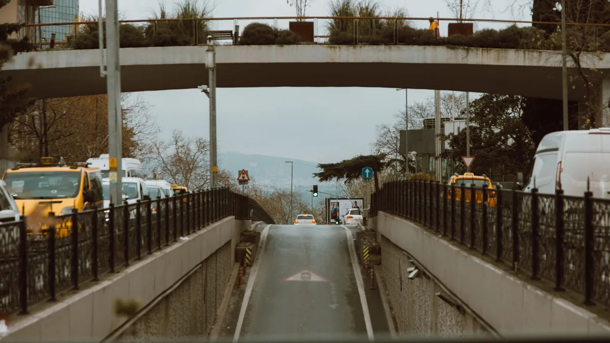 歩道橋の下を車が行き交う街なかの道