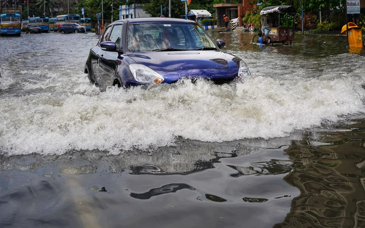 大雨のあと、水の中を進む車。タイヤの半分が水に隠れている