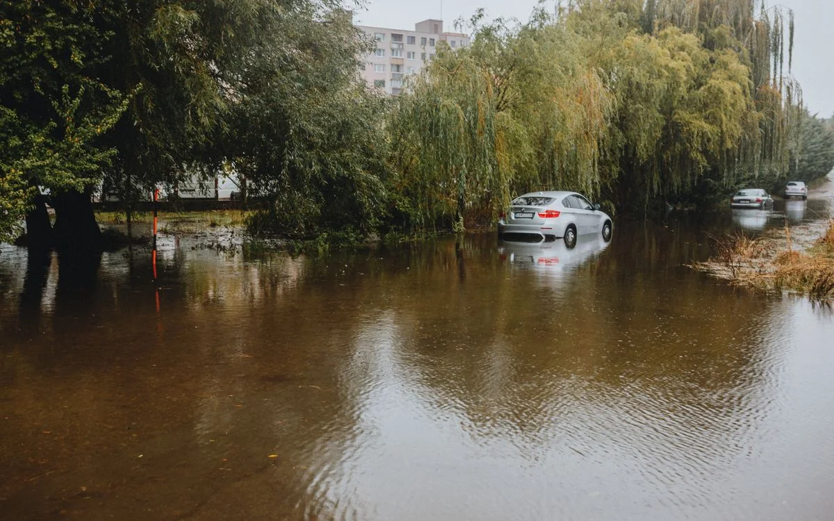 冠水した道に取り残された車。水面が路面と縁石の境を消している
