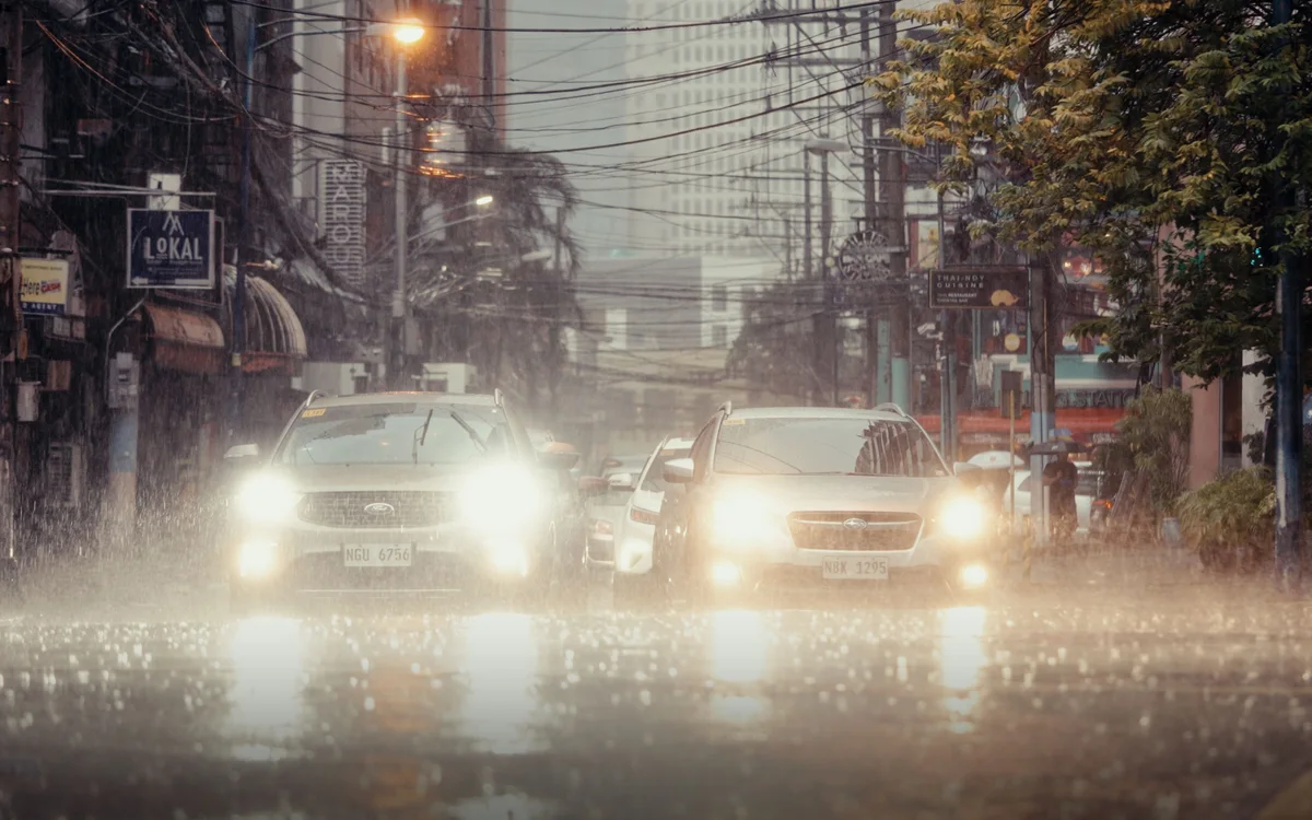 夜の街を走る車。雨の中では、路面の水の深さは見えない