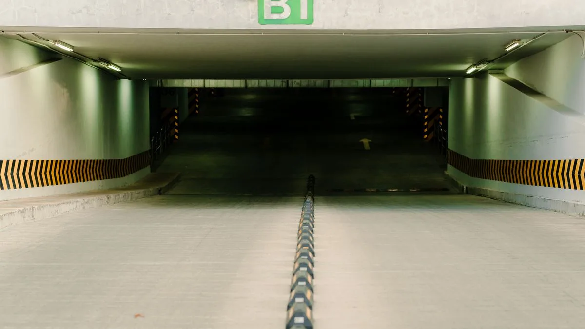地下駐車場へ下りていくスロープ。入口の上に「B1」の表示があり、奥は暗い