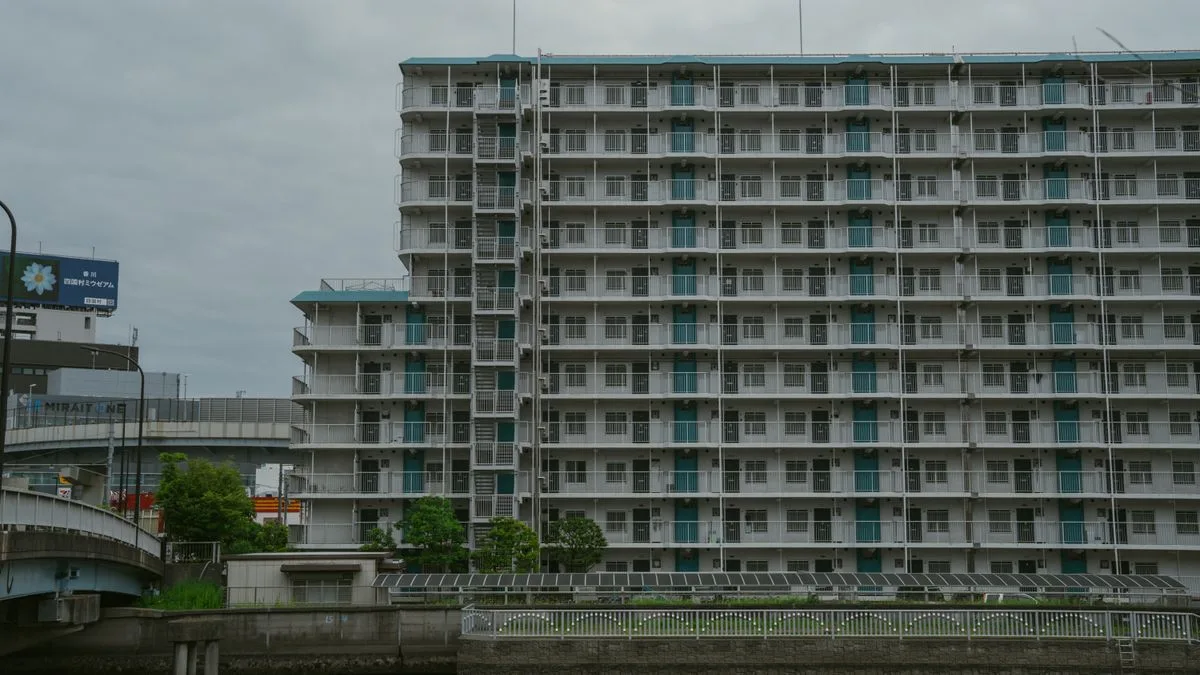 川沿いに建つ日本の集合住宅。同じ形の住戸が並んでいる