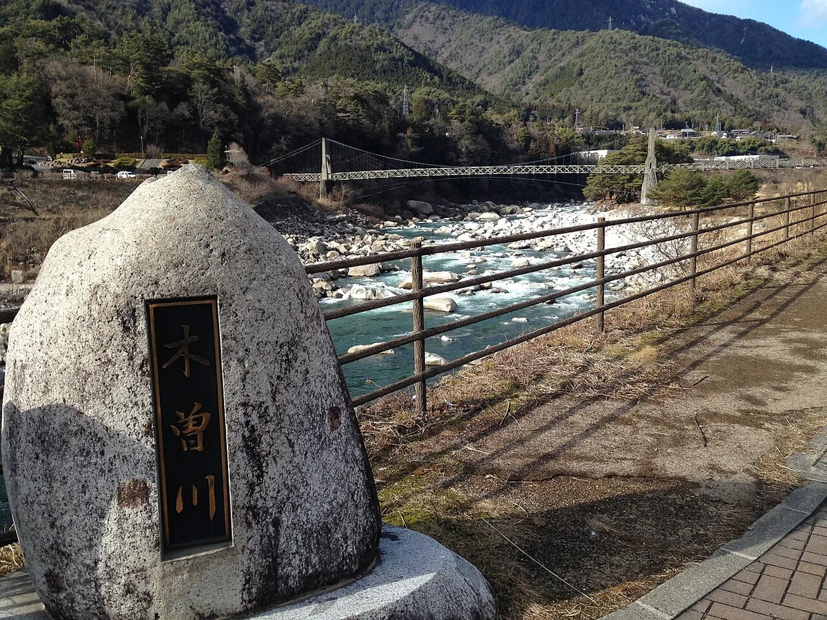南木曽駅の近くを流れる木曽川と「木曽川」の石碑、対岸の山