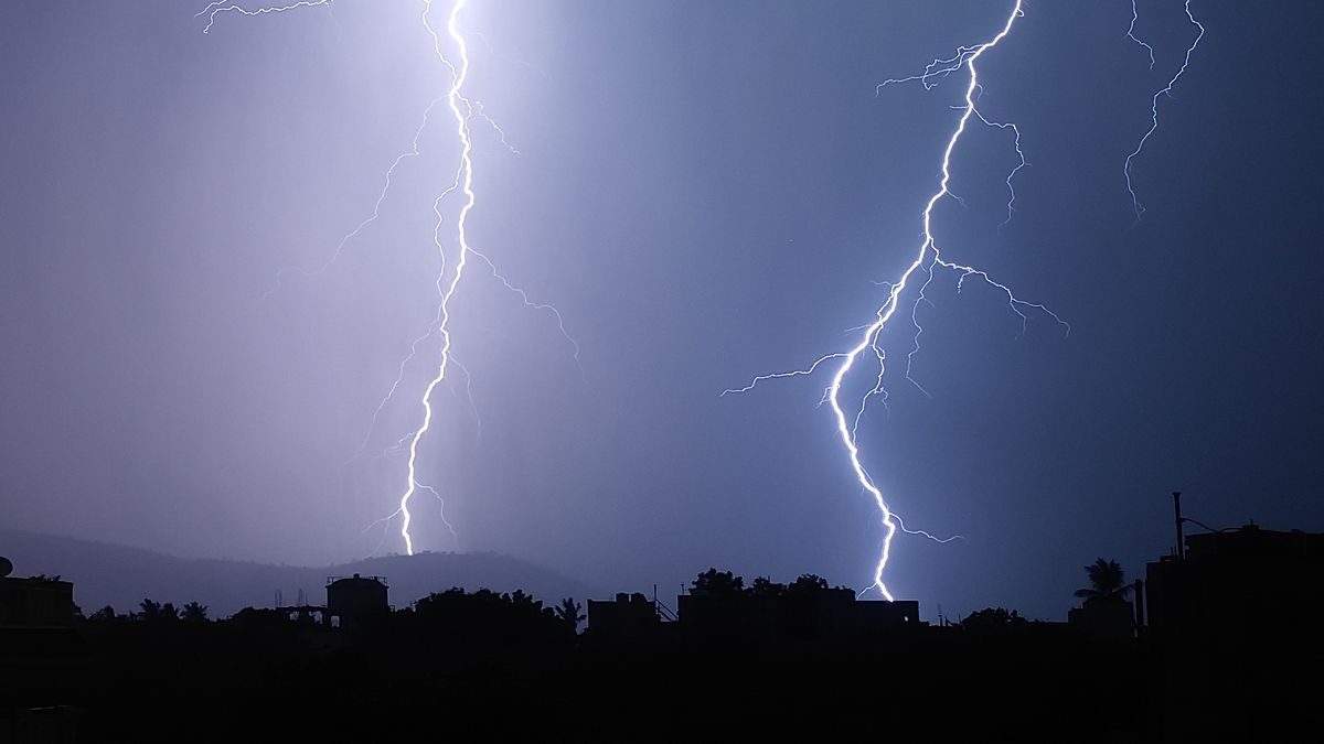 夜の街の上空に落ちる雷。稲妻が2本、地上へ向かって伸びている