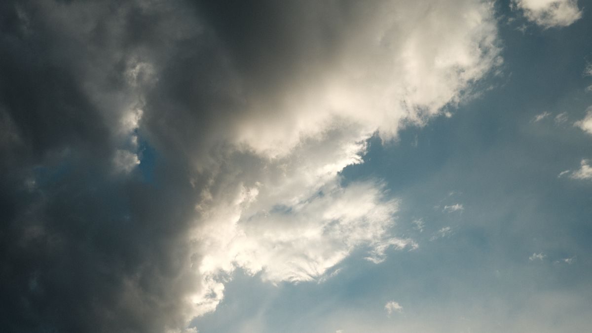 黒く重い雲が空をおおい、雲の切れ間から光がもれている