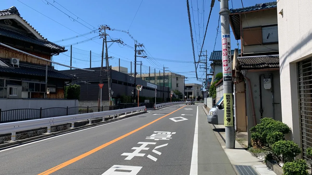 日本の住宅街の道路。人の姿がなく、両側に戸建てが並んでいる