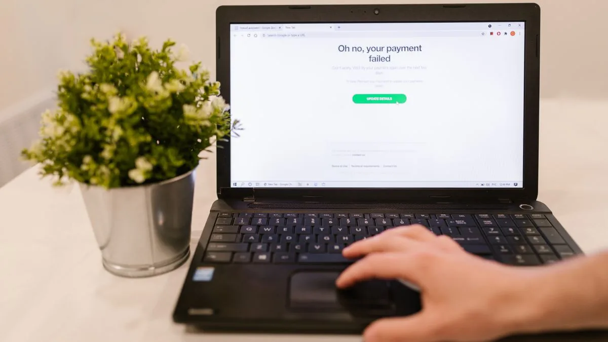 画面にエラー表示が出たノートPCを操作する手元