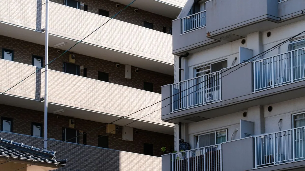築年数の経ったマンションのバルコニー。手前に瓦屋根の家が見える