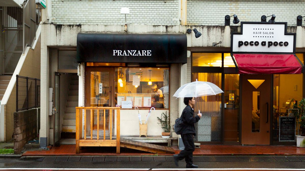 雨の日に傘をさして長袖で歩く人