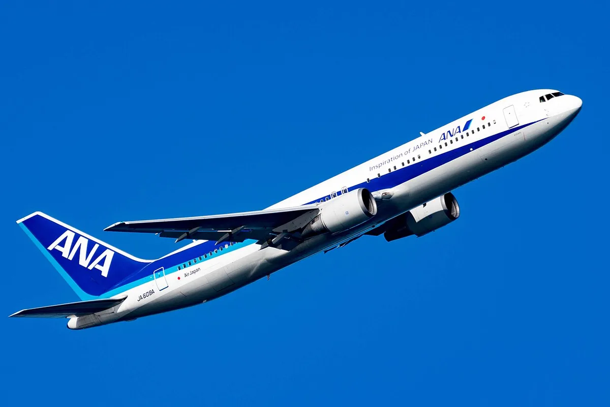 羽田空港を飛び立つANAのボーイング767。白い胴体に青いラインの通常塗装