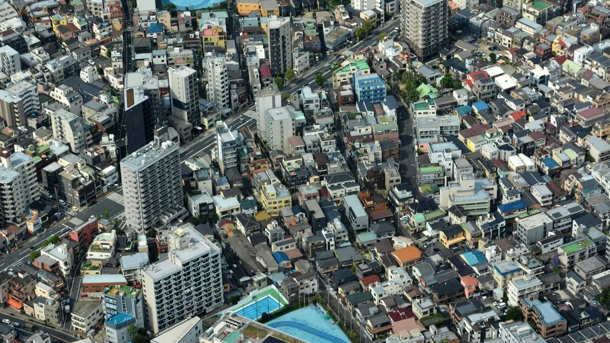 高層マンションと低層の住宅が混ざって並ぶ都市部を、上空から見た写真