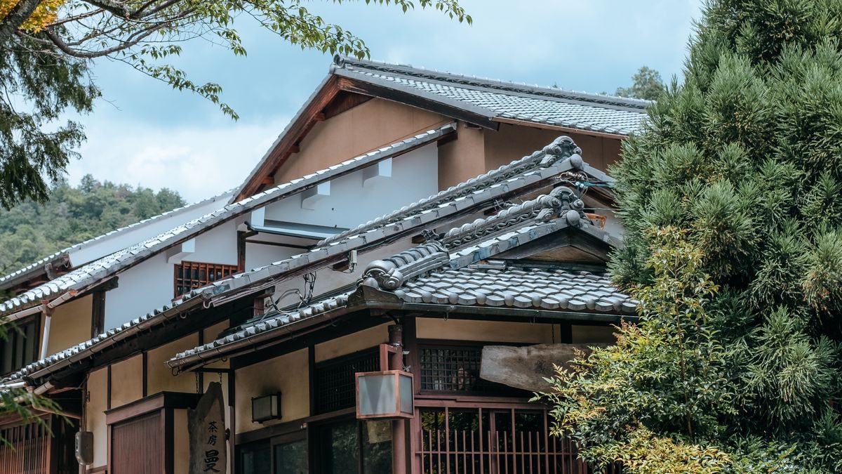 木々に囲まれた瓦屋根の古い日本家屋