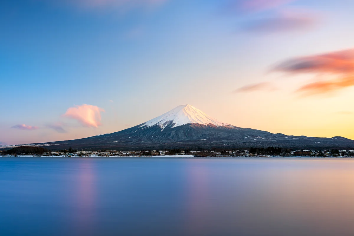 雪を頂く夕暮れの富士山と湖。2025年3月の参考写真