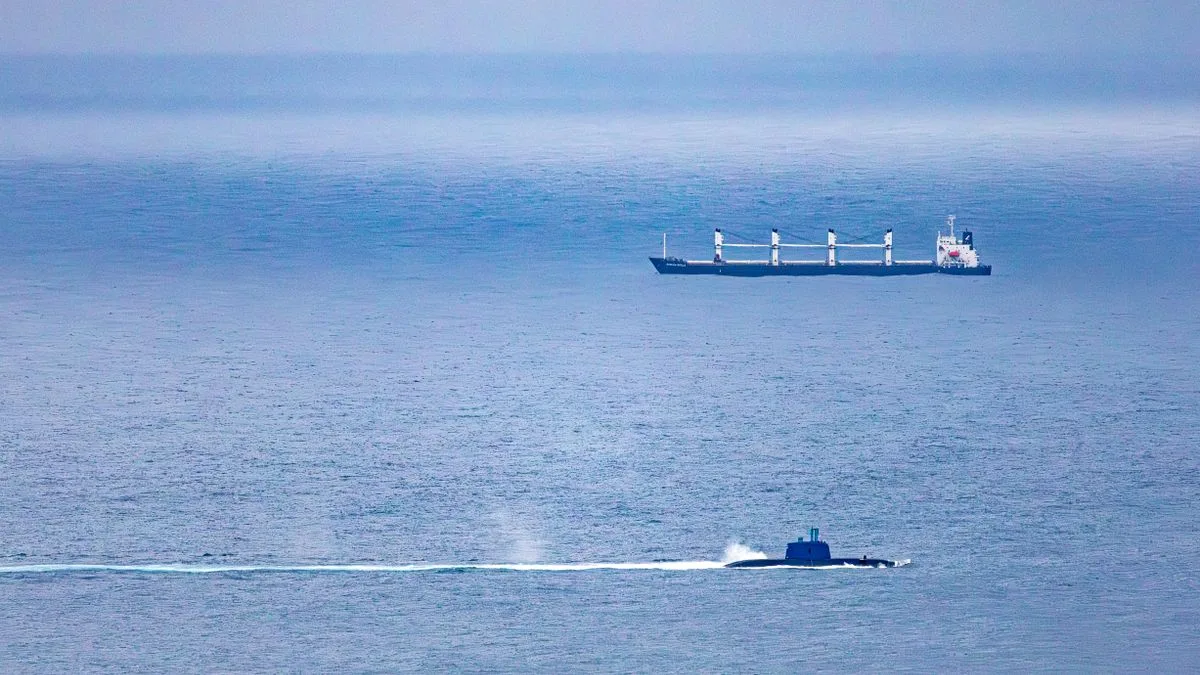 青い海の上に、船と、白い航跡を引いて進む潜水艦が小さく写っている