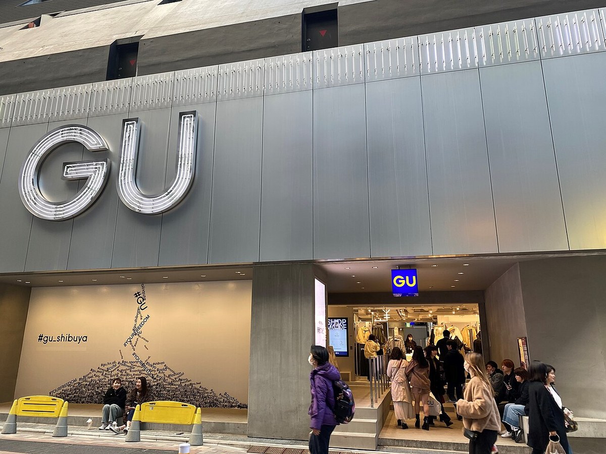ジーユー渋谷店の外観。大きなGUのロゴと、入口に並ぶ買い物客。