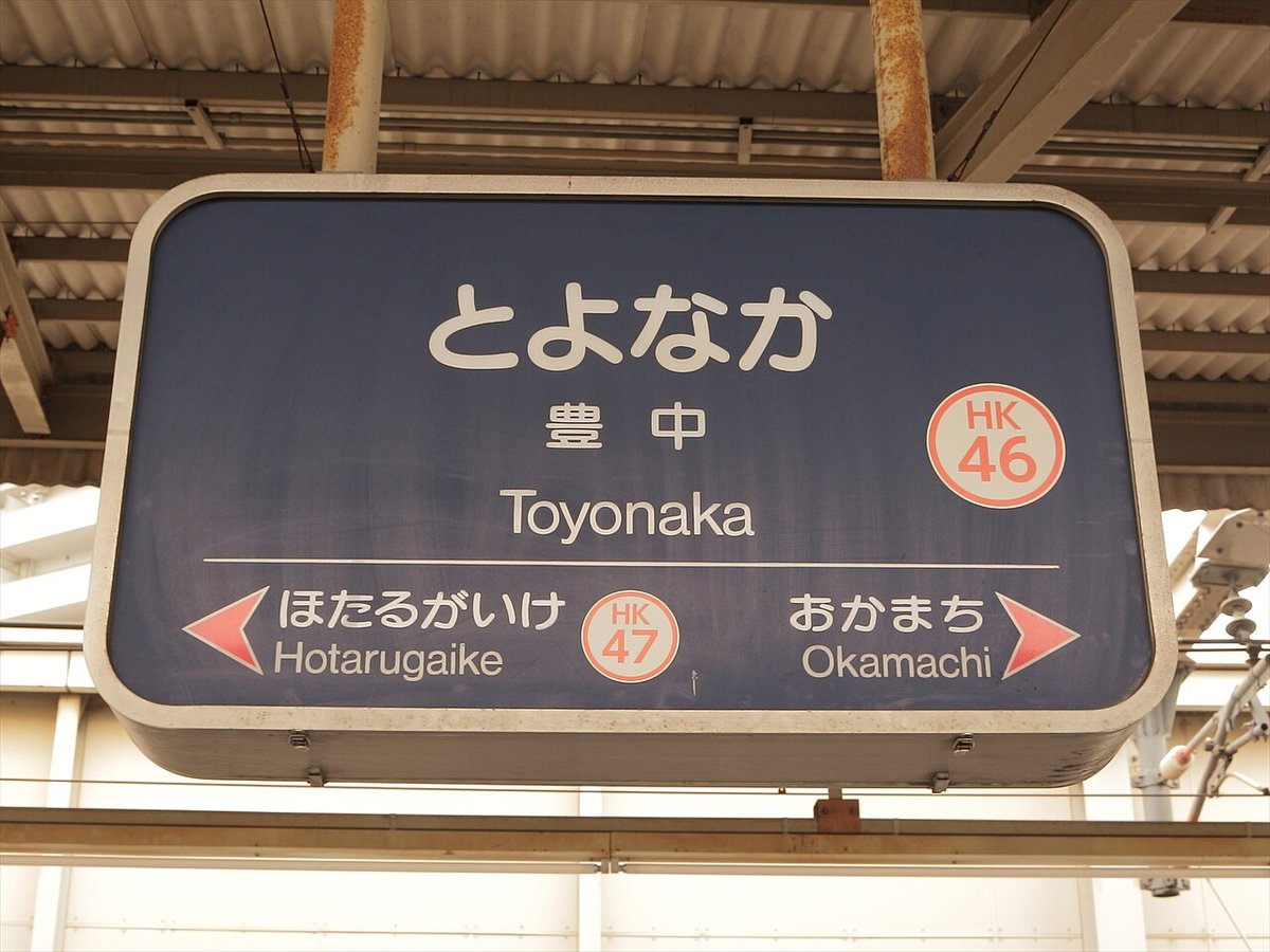 阪急豊中駅のホームにつり下がる駅名標。「とよなか　豊中　Toyonaka」と駅番号HK46、両どなりのほたるがいけ・おかまちが書かれている