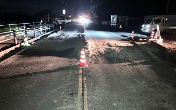 2026年7月の熊本地震のあと、氷川町で段差ができた道路にカラーコーンが並ぶ夜の様子