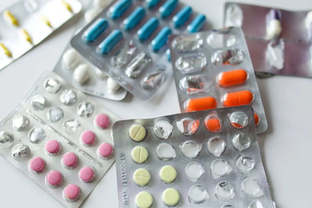 白い台の上に並んだ、色とりどりの錠剤とカプセルのシート