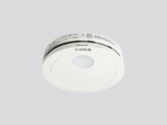 パナソニックの住宅用火災警報器の実物。円形の本体と点検用のボタンが見える