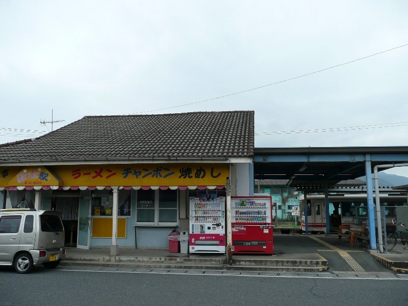 平成筑豊鉄道の勾金駅。瓦屋根の駅舎の横にホームがあり、奥に列車が止まっている