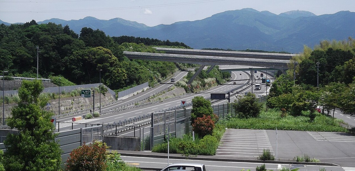新東名高速道路の長泉沼津インターチェンジを西側の高台から見た様子。料金所と、山すそに向かってのびる本線が見える