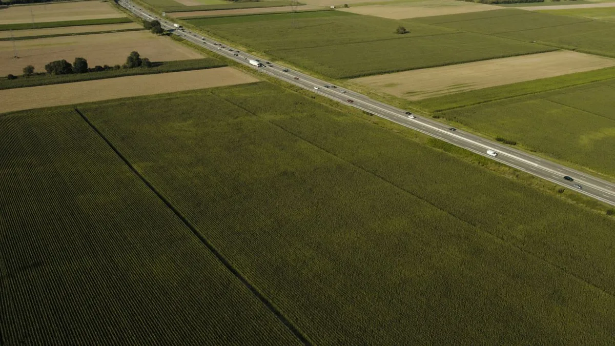 畑のあいだをまっすぐ通る高速道路を、上空から見下ろしている
