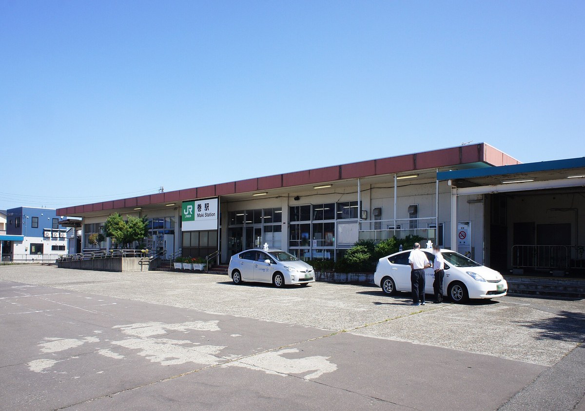 新潟市西蒲区にあるJR越後線の巻駅の駅舎と駅前のロータリー