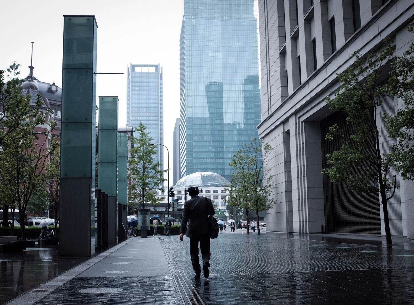 傘を差して雨の街を歩く人のイメージ写真