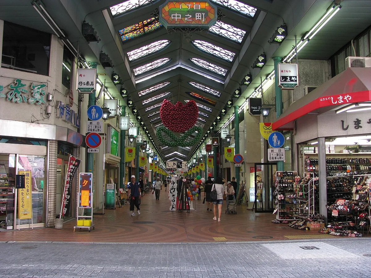 岡山市の表町商店街。ステンドグラスの天井のアーケードに「中之町」の看板が下がり、通りを人が歩いている