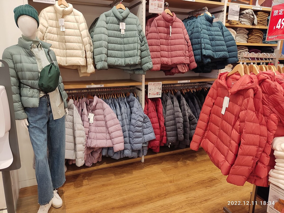 ユニクロの売り場に、ウルトラライトダウンジャケットが緑・ピンク・紺・赤などの色ごとに並んでいる様子。