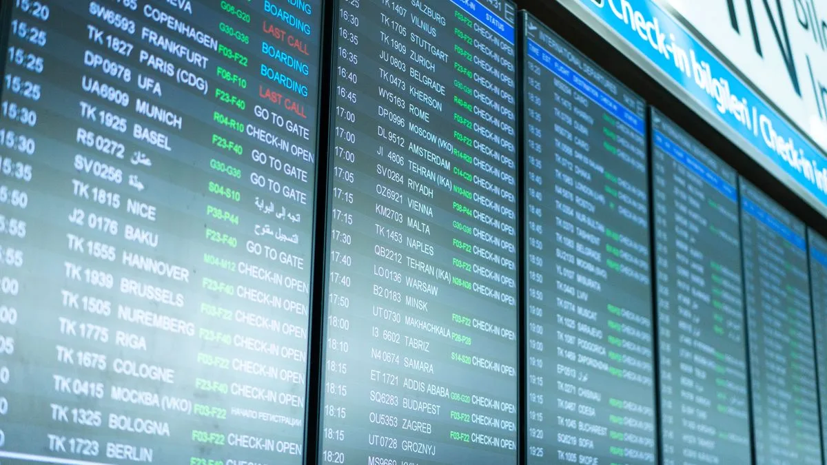 空港の出発案内板に、便名と行き先、搭乗の状況が何列も並んでいる