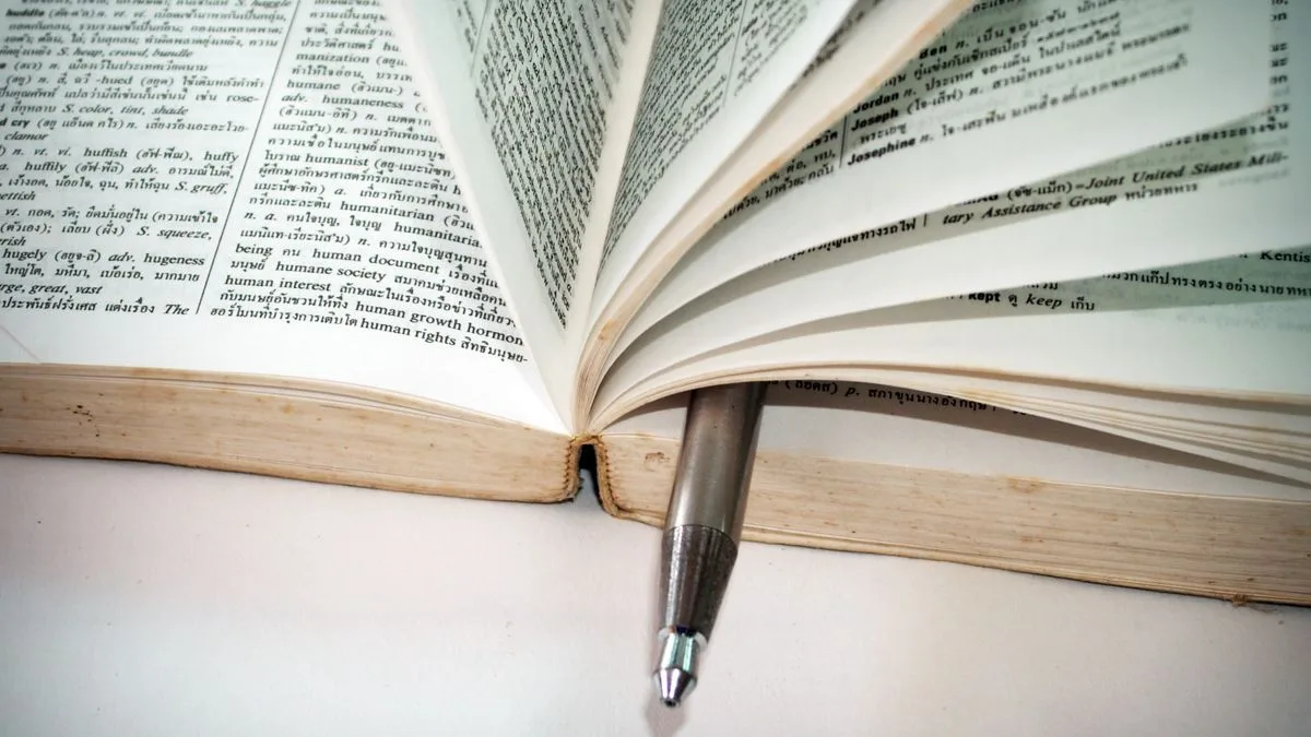 開いた辞書のページのあいだに、ボールペンが挟まれている
